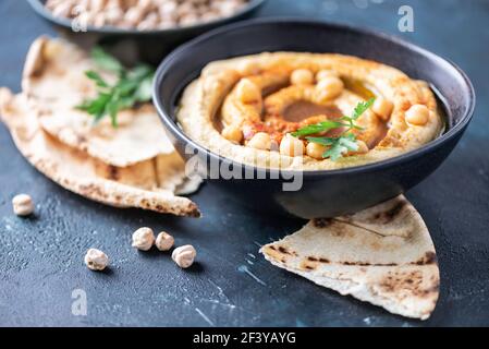 Kichererbsen Hummus, Olivenöl, rohe Kichererbsen, geräucherter Paprika, Pita auf dunklem Hintergrund. Nahöstliche, jüdische Küche oder arabische Gerichte. Draufsicht. Kopieren Stockfoto