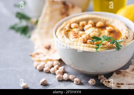 Kichererbsen Hummus, Olivenöl, rohe Kichererbsen, geräucherter Paprika, Pita auf grauem Hintergrund. Nahöstliche, jüdische Küche oder arabische Gerichte. Makroansicht. Kopieren Stockfoto