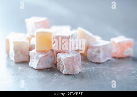 Türkische Delight - rahat Lokum oder Lokum mit Zuckerpulver auf grauem Hintergrund. Traditionelle östliche Küche. Traditionelle Süßwaren aus dem Nahen Osten. Jüdisch Stockfoto