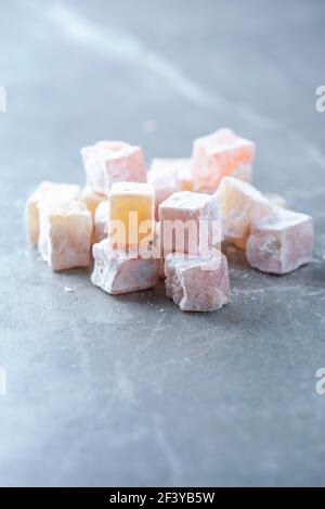 Türkische Delight - rahat Lokum oder Lokum mit Zuckerpulver auf grauem Hintergrund. Traditionelle östliche Küche. Traditionelle Süßwaren aus dem Nahen Osten. Jüdisch Stockfoto