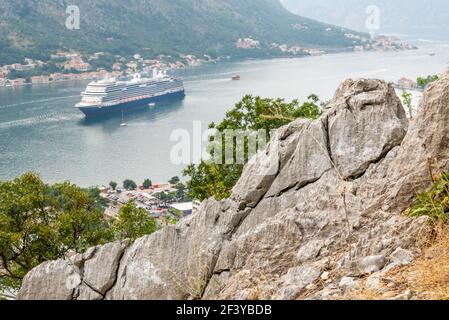 Ein Kreuzfahrtschiff bewegt sich langsam entlang der Bucht wie gesehen Von dem steilen steinigen Weg, der nach Kotor führt Fort und hat spektakuläre Aussichten auf der ganzen Legnth Stockfoto