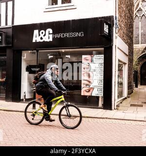 London UK, März 18 2021, man Riding A bicylcle Passing A Closed Hairdressers Shop Covid-19 Coronavirus Lockdown Stockfoto