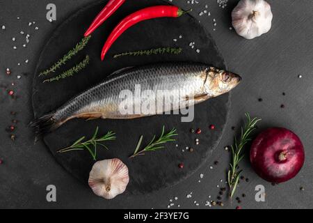 Heringsfisch mit Gemüse auf schwarzem Hintergrund Draufsicht, Konzept des Fischmarktes Stockfoto