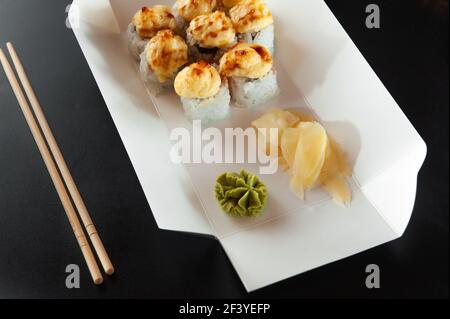 Schnelle Lieferung von heißem Sushi. Das Sushi ist heiß in einer weißen Papierkiste. Stockfoto