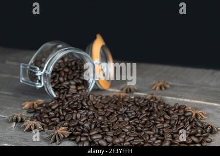 Geröstete Kaffeebohnen im Glas auf altem Vintage-Tisch und dunklem Hintergrund mit Kopierraum. Stockfoto