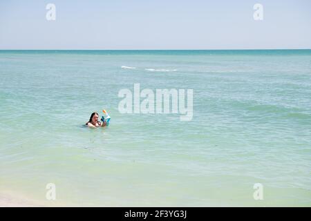 Sanibel Island, USA - 29. April 2018: Bowman's Beach mit Frau schnorcheln in türkisfarbenem Wasser in Maske an sonnigen Tagen, auf der Suche nach Muscheln Muscheln Muscheln, sh Stockfoto