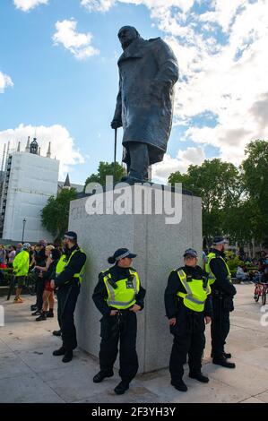 Metropolitan Police Officers rund um die Statue von Sir Winston Churchill, Parliament Square, im Gefolge von BLM Demonstranten beschädigt Statuen. Stockfoto