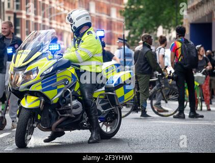 Metropolitan Police Motorrad-Offizier Überwachung Demonstration Demonstranten durch die Straßen von Zentral-London. Stockfoto