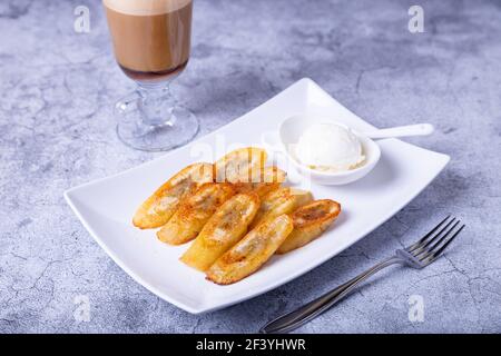 Gebratene Bananen mit Honig, Zimt, Kaffee und Eis. Nahaufnahme. Stockfoto