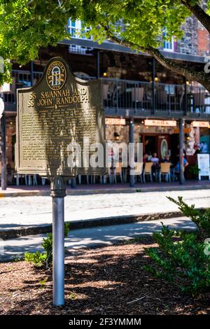 Savannah, USA - 11. Mai 2018: Old Town River Street in Georgia City mit SS Savannah und SS John Randolph Dampfschiff Schild zum Gedenken an Kreuz Stockfoto