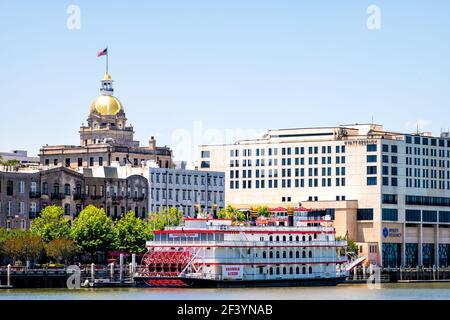 Savannah, USA - 11. Mai 2018: Skyline von der Stadt an der Uferpromenade der Altstadt mit dem Kreuzfahrtschiff Georgia Queen, goldener Kuppel und Rathaus Stockfoto