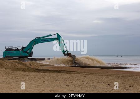Bournemouth, Dorset, Großbritannien. 18th. März 2021. Am Strand von Bournemouth wird der Sand von einem Bagger durch Rohre aus dem Meer auf die Strandküste gepumpt. Mit mehr Menschen wahrscheinlich zu bleiben in diesem Jahr und Urlaub in Bournemouth die goldenen Sandstrände sind Teil der Attraktion. Ovenden SK500 Bagger - Wasser und Sand werden ausgepumpt und sprudeln. Die Möwen sind dabei, es zu überprüfen! Quelle: Carolyn Jenkins/Alamy Live News Stockfoto