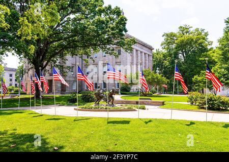 Raleigh, USA - 12. Mai 2018: North Carolina Vietnam Veteran's Monument mit drei Soldaten, die verwundeten Kameraden mit einer Reihe amerikanischer Flagge tragen Stockfoto