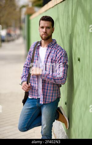 Attraktiven jungen Mann, der im städtischen Hintergrund. Guy legere Kleidung. Lifestyle Konzept. Stockfoto