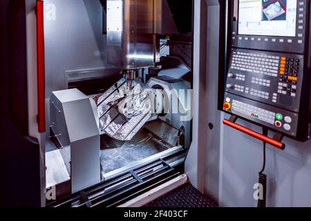 Metallbearbeitung CNC-Fräsmaschine. Schneiden von Metall Moderne Prozessin. Metallbearbeitung CNC-Fräsmaschine. Metall schneiden Moderne Verarbeitungstechnik. Geringe Schärfentiefe. Warnung: Authentische Aufnahmen unter schwierigen Bedingungen. Ein wenig Korn und vielleicht verschwommen. Stockfoto