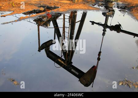 Cabimas, Zulia, Venezuela- 05-10-2017.Ein Pumpenheber spiegelt sich in einer Rohölpest in einem Ölfeld wider. Foto: José Bula U. Stockfoto