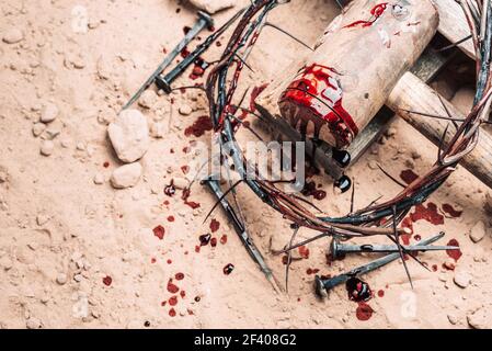 Karfreitag, Passion Jesu Christi. Dornenkrone, Hammer, blutige Nägel auf dem Boden. Christlicher Osterurlaub. Draufsicht, Kopierbereich. Kreuzigung Stockfoto