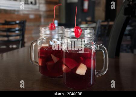 Glas mit kaltem Getränk mit Eis und roten Früchten mit Alkohol Stockfoto