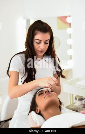 Ästhetik Anwenden einer Maske auf das Gesicht einer schönen Frau in modernes Wellnesscenter. Schönheit und ästhetische Konzepte. Stockfoto