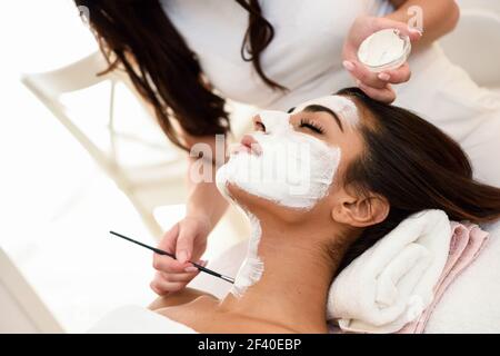 Ästhetik Anwenden einer Maske auf das Gesicht einer schönen Frau in modernes Wellnesscenter. Schönheit und ästhetische Konzepte. Stockfoto