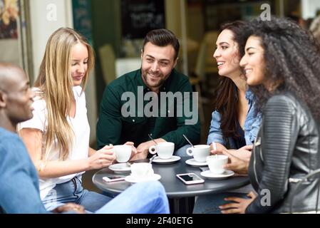 Multiethnische Gruppe von fünf Freunden einen Kaffee zusammen. Drei Frauen und zwei Männer im Cafe, reden, lachen und ihre Zeit genießen. Lifestyle und Freundschaft Konzepte mit realen Menschen Modelle Stockfoto