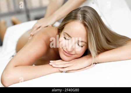 Junge blonde Frau mit Massage im Spa. Massage und Körperpflege. Körper Massage. Lächelnd weibliche. Stockfoto