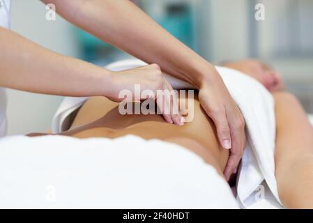 Die Patientin wird von einem professionellen Osteopathietherapeuten behandelt. Frau mit Abdomen Massage in einem Physiotherapie-Zentrum.. Frau mit Abdomen Massage von professionellen Osteopathie Therapeuten Stockfoto