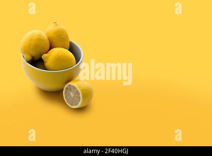 Schüssel voll mit Zitronen isoliert auf gelbem Hintergrund mit Kopie Platz Stockfoto