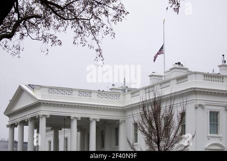 Die US-Nationalflagge fliegt auf halbem Stab über dem Weißen Haus in Washington, DC, USA, 18. März 2021. US-Präsident Joe Biden ordnete an, dass Nationalflaggen auf die Hälfte der Mitarbeiter geflogen werden, um die Opfer der Erschießungen in der Gegend von Atlanta zu ehren, bei denen acht Menschen getötet wurden. Stockfoto