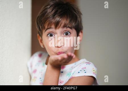 Lustige kleine Mädchen, acht Jahre alt, weht einen Kuss in die Kamera.. Lustige kleine Mädchen, acht Jahre alt, weht einen Kuss Stockfoto