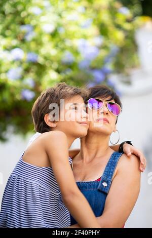 Mutter und ihre kleine Tochter reisen zusammen im städtischen Hintergrund. Frauen tragen Sonnenbrillen. Mutter und ihre kleine Tochter reisen zusammen im städtischen Hintergrund. Stockfoto