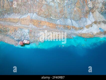 Verlassene Kupfermine auf dem Berg Alesto, Zypern. Abstrakter Hintergrund mit blauem See, bunten Felsen und rostigen Minenstrukturen. Die Aussicht war schrecklich Stockfoto