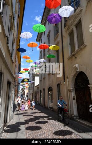 Rovereto. Italien. Bunte Sonnenschirme an der Via Orefici im historischen Zentrum der Stadt. Stockfoto