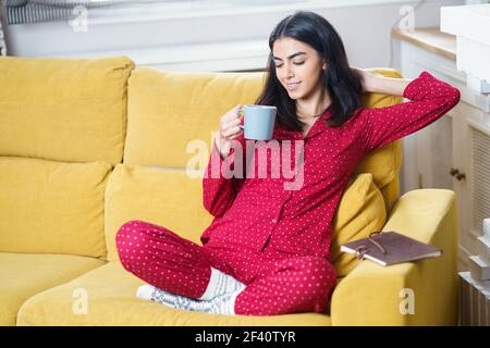 Persische Frau zu Hause mit Tee und Lesen. Frau zu Hause mit Tee und Lesen Stockfoto