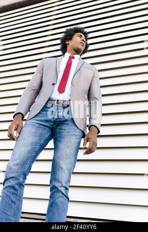 Schwarz zuversichtlich Geschäftsmann tragen Anzug zu Fuß in städtischen Hintergrund. Mann mit afro Haar.. Schwarzer Geschäftsmann trägt Anzug zu Fuß in städtischen Hintergrund. Stockfoto