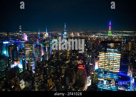 Nachtszene in Manhattan, New York City mit vielen beleuchteten Gebäuden in einer dunklen Nacht Stockfoto