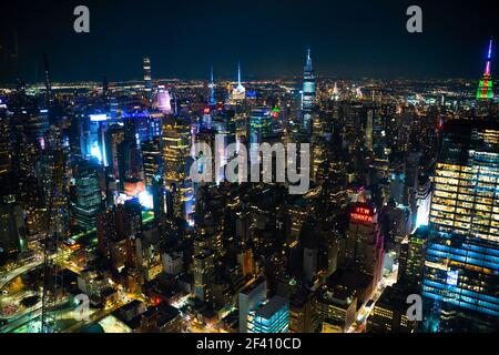 Nachtszene in Manhattan, New York City mit vielen beleuchteten Gebäuden in einer dunklen Nacht Stockfoto