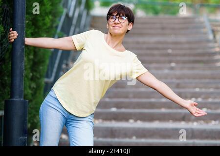 Lustige glückliche Frau mittleren Alters tragen Brillen in einem Stadtpark. Lustige glückliche Frau mittleren Alters in einem Stadtpark. Stockfoto