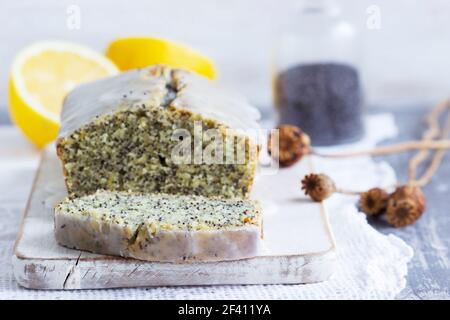 Zitronenkuchen mit Mohnsamen, bedeckt mit Glasur auf hellem Hintergrund. Stockfoto
