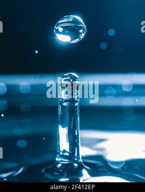 Farbiger Wassertropfen, kreisförmige Wellen, Wasserspritzer, Nahaufnahme. Stockfoto