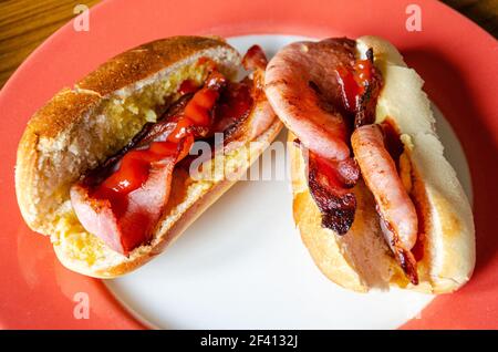 Frische, hausgemachte Speckbrötchen mit Tomatenketchup in frisch gebackenem Brot. Stockfoto