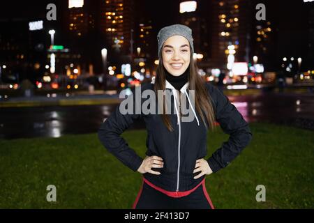 Die lächelnde während bereitet sich auf eine Nacht laufen um die Große Stadt Stockfoto