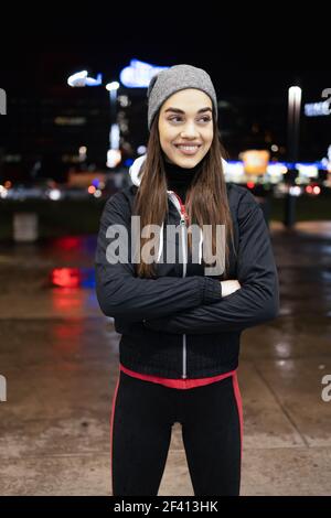 Die lächelnde während bereitet sich auf eine Nacht laufen um die Stadt Stockfoto