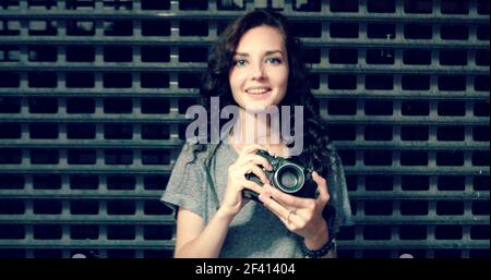 Hipster Mädchen mit vintage Fotokamera Nahaufnahme, kopieren Raum, getönte Bild. Hipster Mädchen mit vintage Fotokamera Nahaufnahme, kopieren Raum, getönte Stockfoto