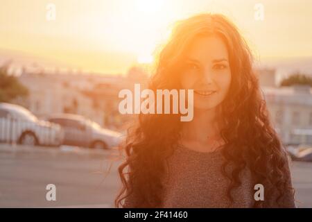 Schönheit Mädchen im Freien genießen Stadt Abendzeit. Schöne Teenage Modell Mädchen mit langen Haaren in Sun Glow . Kostenlose Glückliche Frau. Das Bild wird in warmen Farben getönt. Schönheit Mädchen im Freien genießen Stadt Abendzeit. Schöne Teenage Model Mädchen mit langen Haaren in glühenden Sonne. Free Happy Woman. In warmen Farben getönt Stockfoto