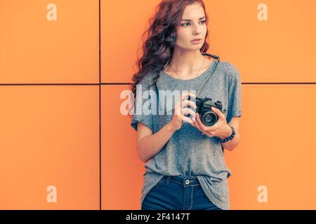 Broody Hipster Girl Photographer Looking Away With Vintage Film Camera In Her Handversuchen Sie, Alle Original-Dinge Zu Fing, Um Foto, Copyspace. Broody Hipster Girl Fotografin Schaut Weg Mit Vintage-Filmkamera In Ihren Händen Stockfoto