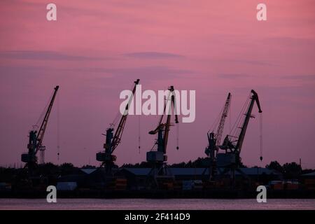 Silhouetten Von Wharf Cranes Vor Dem Sonnenuntergang Himmel. Wharf Cranes Vor Dem Sonnenuntergang Himmel Stockfoto