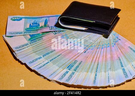 Spaß an russischen Geld Rubel in einer Leder-Brieftasche auf Bastelpapier Hintergrund. Spaß an russischem Geld in einer Ledertasche auf Bastelpapier Hintergrund Stockfoto