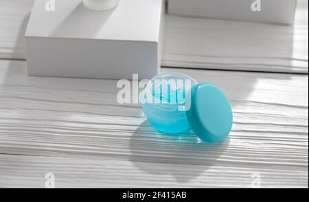 Öffnen Sie den blauen Gelbehälter auf dem weißen Holztisch Stockfoto