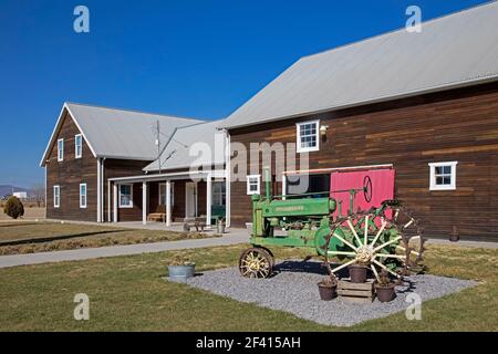 John Deere-Traktor mit Jahrgang 1930s vor dem traditionellen Mennoniten-Milchviehbetrieb in Cuauhtémoc, Chihuahua, Mexiko Stockfoto